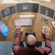 A man with a Quest headset has multiple VR screens open with Microsoft products.